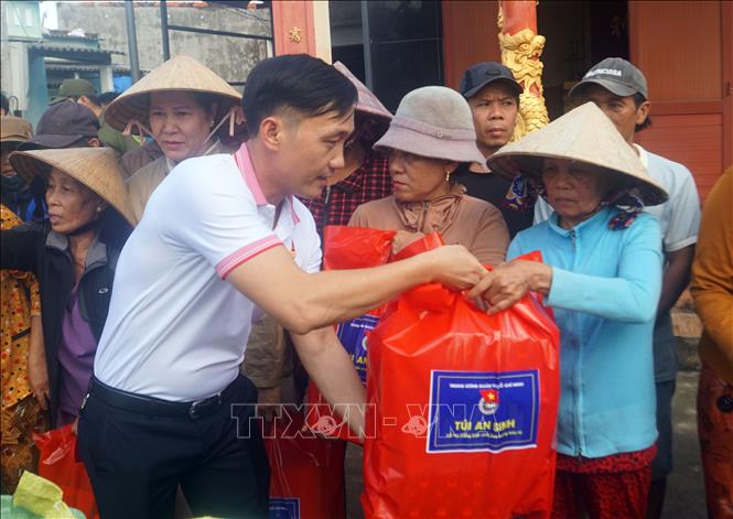 Đoàn công tác tặng túi an sinh cho người dân xã Tuy Phước Đông. Ảnh: Trịnh Bang Nhiệm - TTXVN
