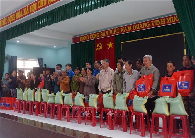 Đoàn công tác tặng túi an sinh cho người dân xã Tuy Phước Bắc. Ảnh: Trịnh Bang Nhiệm - TTXVN