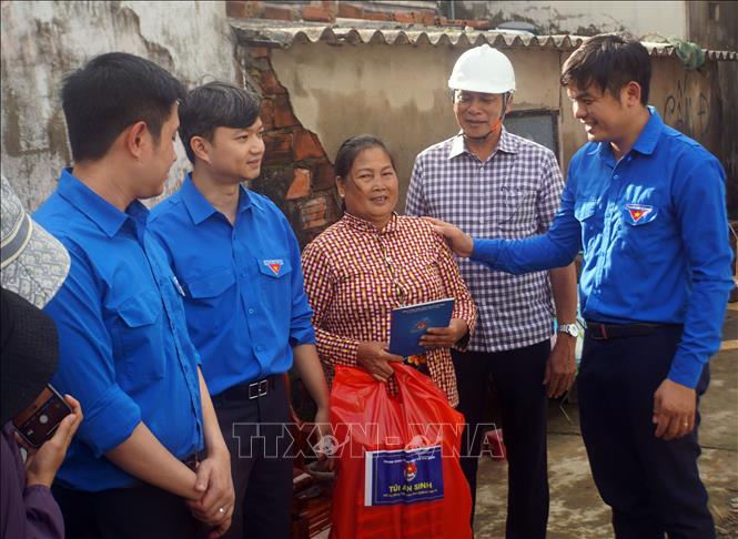 Đoàn công tác tặng quà cho một gia đình người dân bị sập nhà ở tại xã Tuy Phước Đông. Ảnh: Trịnh Bang Nhiệm - TTXVN