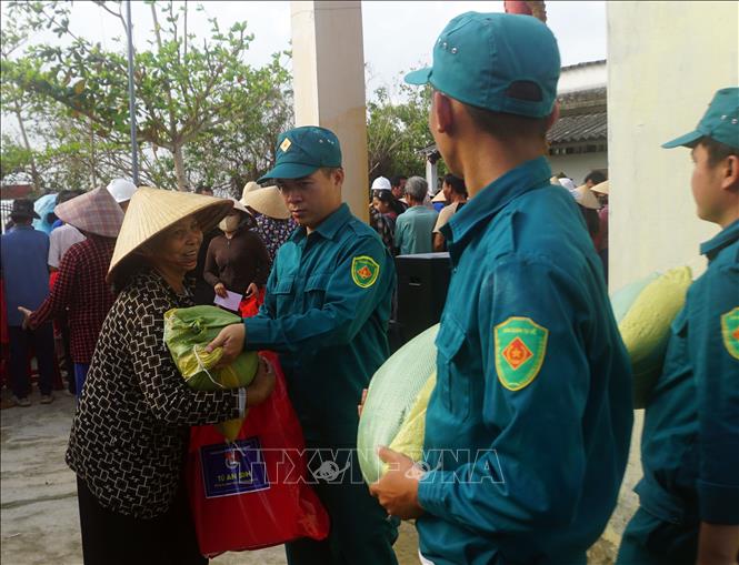 Người dân xã Tuy Phước Đông nhận gạo do Đoàn công tác tặng. Ảnh: Trịnh Bang Nhiệm - TTXVN