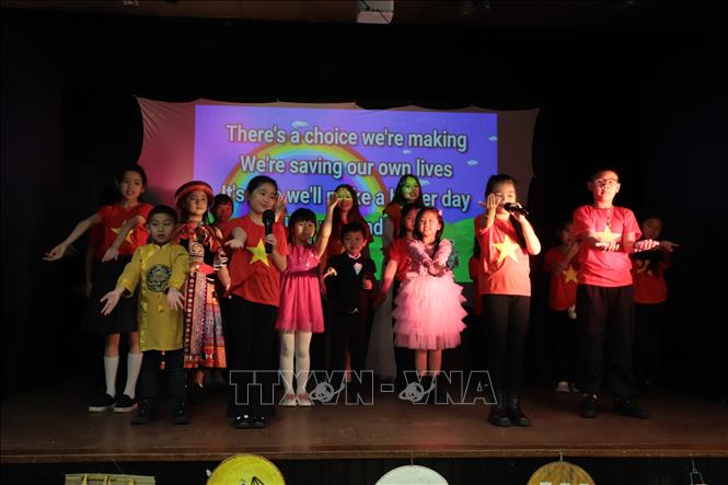 Tiết mục đồng diễn của trẻ em trong trang phục dân tộc và áo cờ đỏ sao vàng gây xúc động với kiều bào tại Anh. Ảnh: Phong Hà - PV TTXVN tại Anh