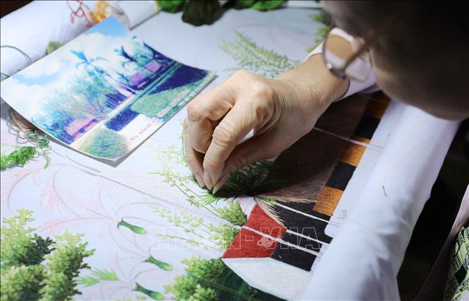 An artisan works in silence, meticulously crafting each stitch. VNA Photo: Thế Duyệt 