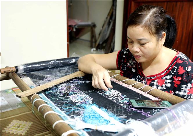 Amidst the hustle and bustle of life, people in Thu Tri commune, Hung Yen province still work diligently and tirelessly on their embroidery frames, meticulously stitching each needle and thread to preserve their traditional craft. VNA Photo: Thế Duyệt
