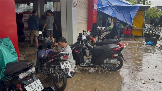 Sửa chữa xe máy bị ngập nước do mưa lũ gây ra. Ảnh: Nguyên Dung - TTXVN