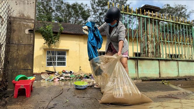 Người dân thu dọn, vệ sinh nhà cửa để quay trở lại nhịp sống thường ngày. Ảnh: Nguyên Dung - TTXVN