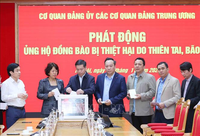 Các đồng chí lãnh đạo Đảng uỷ các cơ quan Đảng Trung ương ủng hộ đồng bào khắc phục hậu quả bão lũ. Ảnh: Phương Hoa - TTXVN