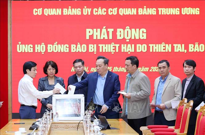 Các đồng chí lãnh đạo Đảng uỷ các cơ quan Đảng Trung ương ủng hộ đồng bào khắc phục hậu quả bão lũ. Ảnh: Phương Hoa - TTXVN