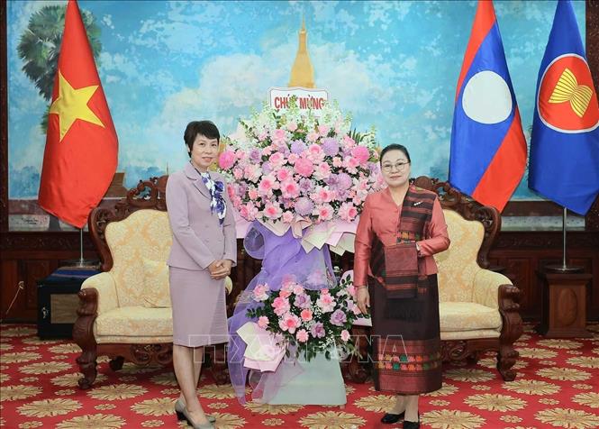 Tổng Giám đốc TTXVN Vũ Việt Trang tặng lẵng hoa chúc mừng Đại sứ Lào tại Việt Nam Khamphao Ernthavanh nhân dịp kỷ niệm 50 năm Quốc khánh nước CHDCND Lào. Ảnh: Hoàng Hiếu - TTXVN