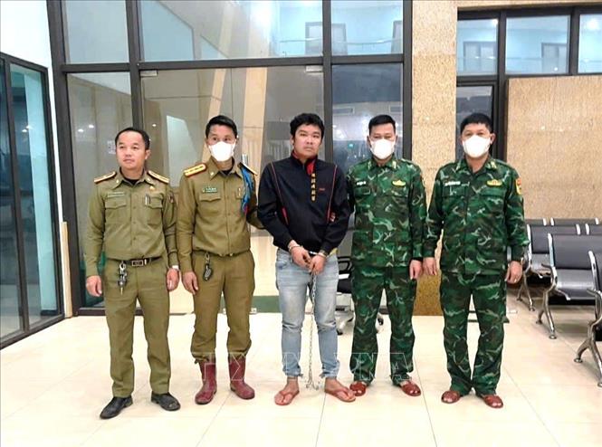 Công an nước bạn Lào bàn giao các đối tượng cho Đồn Biên phòng cửa khẩu quốc tế La Lay (Bộ đội Biên phòng tỉnh Quảng Trị). Ảnh: TTXVN phát 