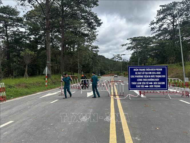 Lực lượng chức năng phường Xuân Hương- Đà Lạt dỡ bỏ rào chắn cho thông xe qua đèo Prenn sau gần 10 ngày bị phong tỏa. Ảnh: Chu Quốc Hùng- TTXVN