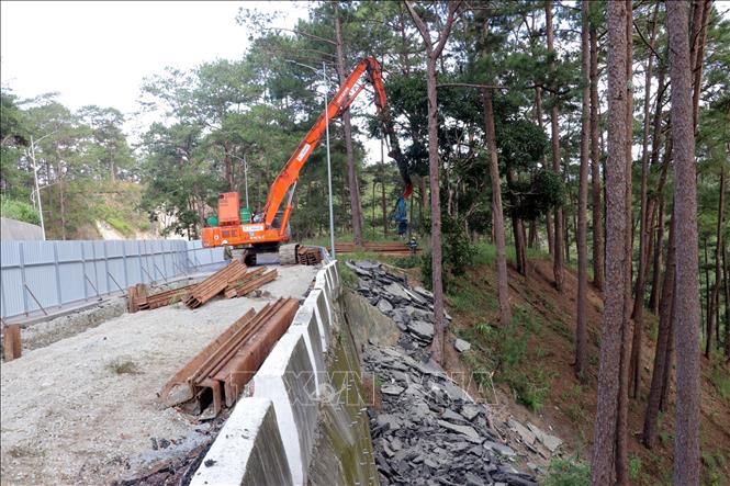 Đơn vị thi công đóng cọc ván thép để gia cố tạm thời mặt đường chống sạt lở. Ảnh: Chu Quốc Hùng- TTXVN