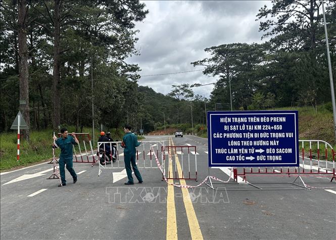  Lực lượng chức năng phường Xuân Hương- Đà Lạt dỡ bỏ rào chắn cho thông xe qua đèo Prenn sau gần 10 ngày bị phong tỏa. Ảnh: Chu Quốc Hùng- TTXVN