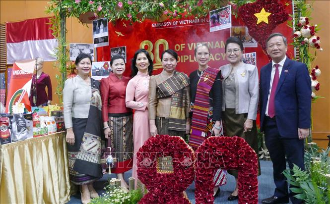 Các nữ cán bộ ngoại giao và các phu nhân đoàn Lào ghé thăm khu trưng bày “80 năm ngoại giao Việt Nam: Hòa bình và Phát triển” tại sự kiện. Ảnh: Xuân Tú - PV TTXVN tại Lào