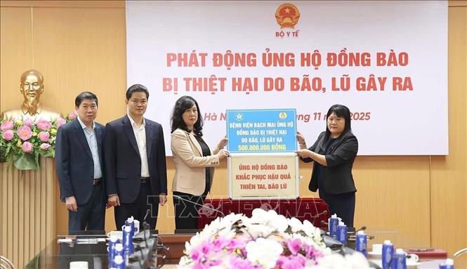 Đại diện bệnh viện Bạch Mai ủng hộ đồng bào bị thiệt hại do bão, lũ gây ra. Ảnh: TTXVN 