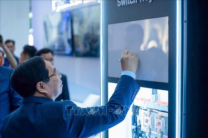 Thủ tướng Phạm Minh Chính ký tên lưu niệm vào bộ chuyển vi mạch NVLINK sử dụng cho siêu máy chủ tiên tiến nhất NVIDIA. Ảnh: Dương Giang-TTXVN 
