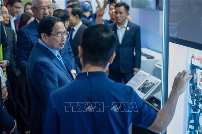 Thủ tướng Phạm Minh Chính ký tên lưu niệm vào bộ chuyển vi mạch NVLINK sử dụng cho siêu máy chủ tiên tiến nhất NVIDIA. Ảnh: Dương Giang-TTXVN 
