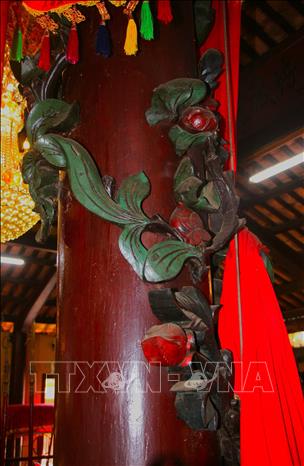 Trên các cột gỗ có họa tiết hình rồng, hoa mẫu đơn được chạm khắc tinh xảo. Ảnh: Nguyễn Hằng – TTXVN