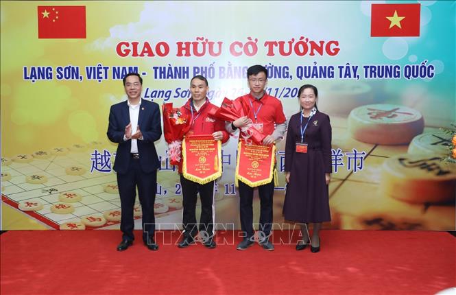 Đại diện 2 đội tuyển Cờ tướng nhận hoa và cờ lưu niệm. Ảnh: Anh Tuấn – TTXVN