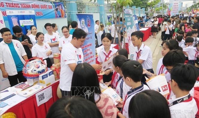 Tình nguyện viên tuyên truyền kiến thức về phòng chống HIV/AIDS cho học sinh tại Lễ mit-tinh hưởng ứng Tháng hành động Quốc gia phòng, chống HIV/AIDS năm 2024 và Ngày thế giới phòng, chống AIDS (1/12) do Sở Y tế Thành phố Hồ Chí Minh tổ chức (30/11/2024). Ảnh: Đinh Hằng - TTXVN 