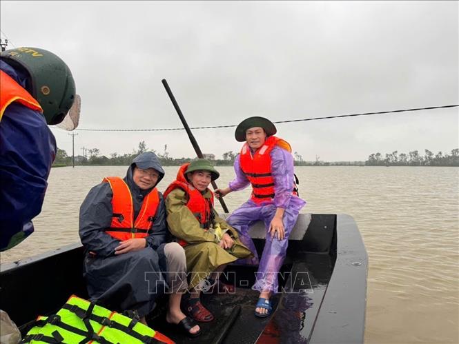 Nhóm phóng viên CQTT Hà Tĩnh tác nghiệp hiện trường mưa lũ ở xã Cẩm Duệ tỉnh Hà Tĩnh. Ảnh: TTXVN