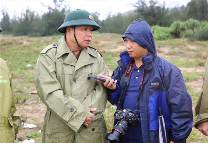 Phóng viên Tá Chuyên, CQTT Thông tấn xã Việt Nam tại Quảng trị tác nghiệp hiện trường. Ảnh: TTXVN