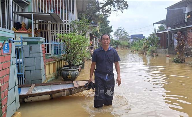 Phóng viên Nguyễn Văn Lý, CQTT Thông tấn xã Việt Nam tác nghiệp hiện trường mưa lũ tại TP Huế. Ảnh: TTXVN