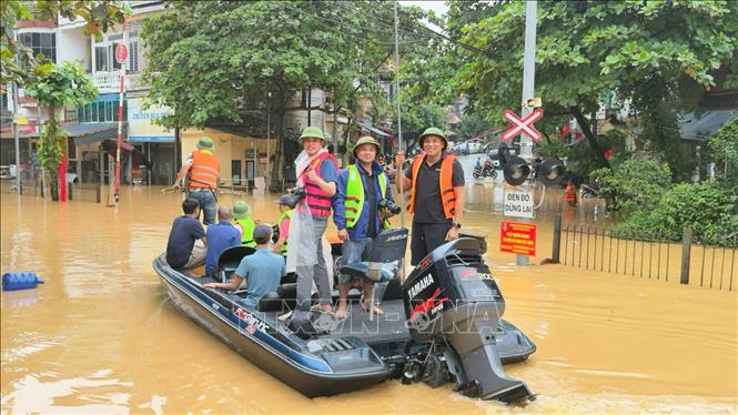 Nhóm phóng viên CQTT Thông tấn xã Việt Nam Lào Cai tác nghiệp tại khu vực ngập lụt do ảnh hưởng của cơn bão số 10 ở phường Yên Bái. Ảnh: TTXVN