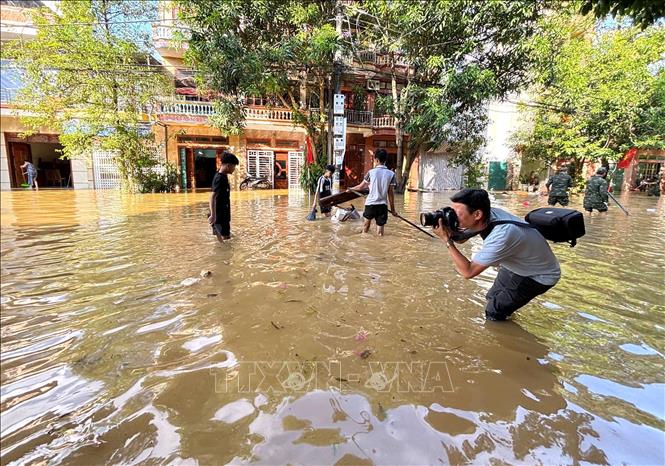 Phóng viên Nguyễn Quang Cường, CQTT tại tỉnh Tuyên Quang tác nghiệp tại phường Minh Xuân, thời điểm cơn bão số 10 gây ảnh hưởng. Ảnh: TTXVN