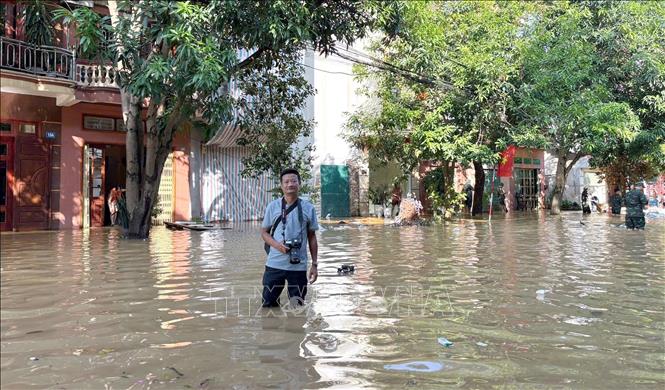 Phóng viên Nguyễn Quang Cường, CQTT tại tỉnh Tuyên Quang tác nghiệp tại phường Minh Xuân, thời điểm cơn bão số 10 gây ảnh hưởng. Ảnh: TTXVN