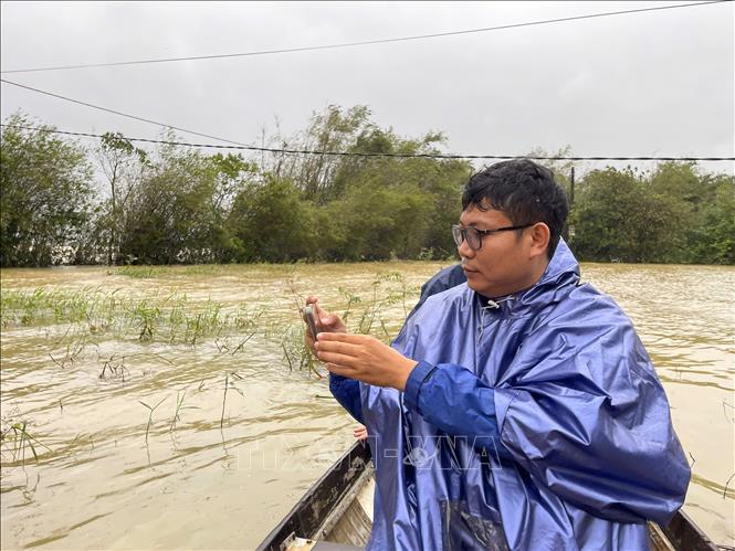 Phóng viên Văn Dũng, CQTT Thông tấn xã Việt Nam tại Huế tác nghiệp tại rốn lũ phường Hóa Châu, thành phố Huế. Ảnh: TTXVN
