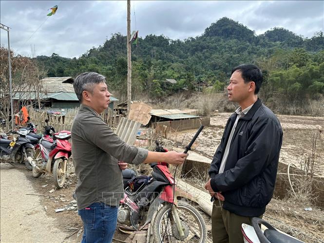 Phóng viên Hoàng Thảo Nguyên, CQTT thông tấn xã Việt Nam tại Thái Nguyên tác nghiệp tại xã Văn Lang - một trong những xã chịu ảnh hưởng nặng nề nhất của bão số 11. Ảnh: TTXVN