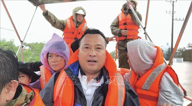 Phóng viên Nguyễn Tường Quân CQTT Đắk Lắk tác nghiệp trong đợt mưa lũ. Ảnh: TTXVN