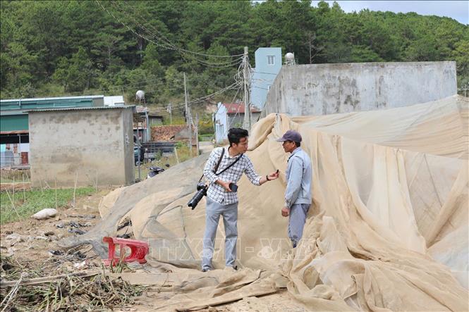 Phóng viên Nguyễn Dũng, CQTT Thông tấn xã Việt Nam tại Lâm Đồng tác nghiệp hiên trường vùng lũ Đơn Dương (Lâm Đồng). Ảnh: TTXVN