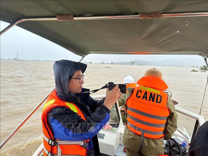 Phóng viên Đỗ Trưởng tác nghiệp tại vùng rốn lũ Hòa Thịnh, tỉnh Đắk Lắk trong đợt mưa lũ lịch sử. Ảnh: TTXVN