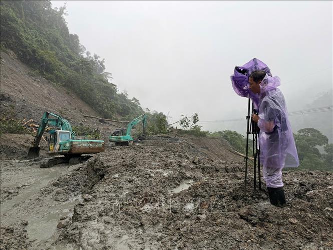 Phóng viên Dư Toán ở CQTT Quảng Ngãi tác nghiệp tại Đèo Lò Xo. Ảnh: TTXVN