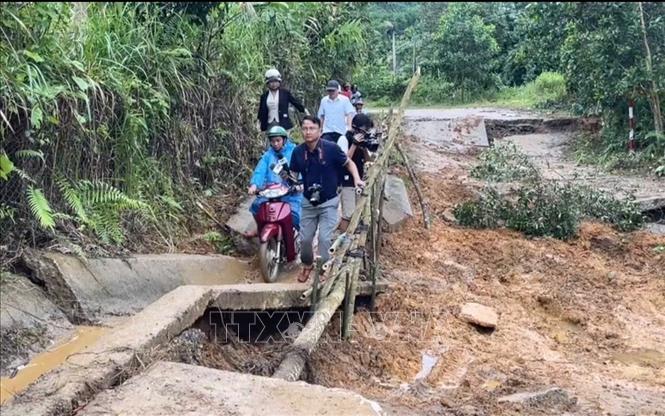 Phóng viên Phạm Cường CQTT Quảng Ngãi tác nghiệp hiện trường vụ sạt lở do ảnh hưởng của bão số 13. Ản: TTXVN