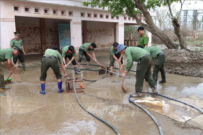 Các chiến sỹ Trường Cao đẳng An ninh nhân dân 1 (Bộ Công an) giúp dọn dẹp bùn đất tại các trường học, trụ sở tại xã Đồng Xuân. Ảnh: Xuân Quý – TTXVN