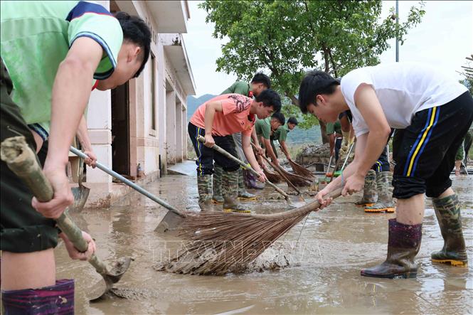 Các chiến sỹ Trường Cao đẳng An ninh nhân dân 1 (Bộ Công an) giúp dọn dẹp bùn đất tại các trường học, trụ sở tại xã Đồng Xuân. Ảnh: Phạm Kha – TTXVN