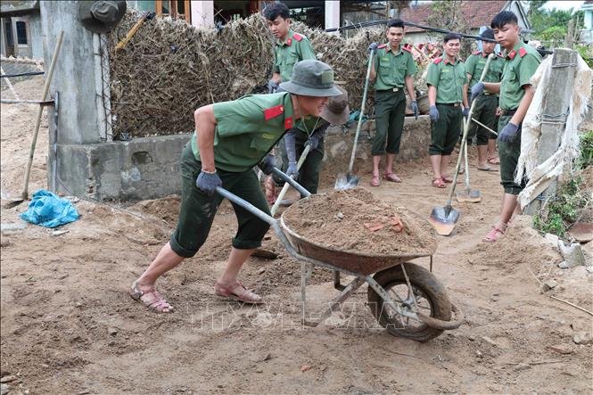 Các chiến sỹ Trường Cao đẳng An ninh nhân dân 1 (Bộ Công an) giúp dọn dẹp bùn đất tại các trường học, trụ sở tại xã Đồng Xuân. Ảnh: Xuân Quý – TTXVN