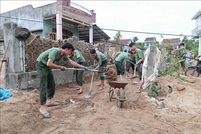 Các chiến sỹ Trường Cao đẳng An ninh nhân dân 1 (Bộ Công an) giúp dọn dẹp bùn đất tại các trường học, trụ sở tại xã Đồng Xuân. Ảnh: Xuân Quý – TTXVN