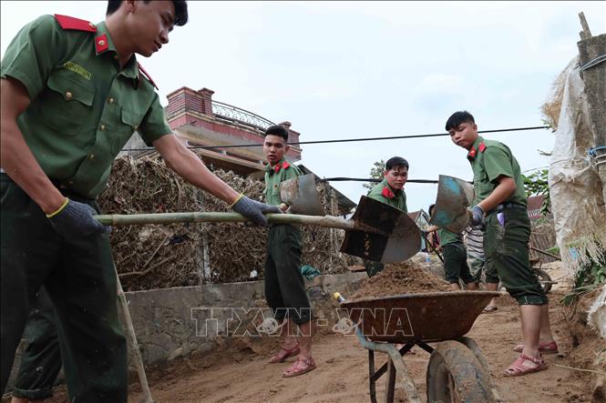 Các chiến sỹ Trường Cao đẳng An ninh nhân dân 1 (Bộ Công an) giúp dọn dẹp bùn đất tại các trường học, trụ sở tại xã Đồng Xuân. Ảnh: Phạm Kha – TTXVN