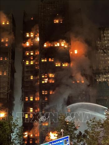 Trong ảnh: Một tòa nhà tại khu chung cư vẫn đang bị cháy. Ảnh: Xuân Vịnh/PV TTXVN  tại Hong Kong