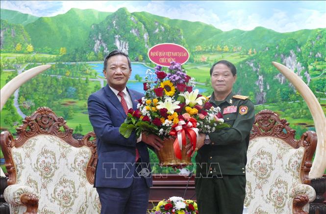 Đại sứ Việt Nam tại Lào Nguyễn Minh Tâm tặng hoa chúc mừng Bộ Quốc phòng Lào nhân dịp Kỷ niệm 50 năm Quốc khánh Lào và 105 Ngày sinh Chủ tịch Kaysone Phonvihane. Ảnh: Xuân Tú - PV TTXVN tại Lào