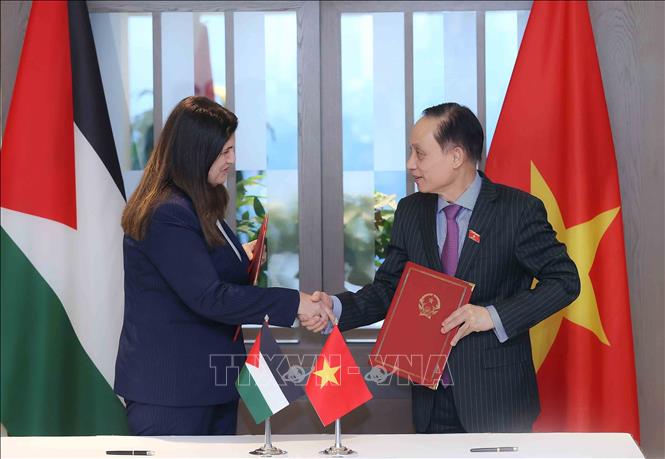  Minister of Foreign Affairs Le Hoai Trung and Palestinian Minister of Foreign Affairs and Expatriates Varsen Aghabekian Shahin sign a visa exemption agreement for diplomatic passport holders of each country./, VNA Photo: An Đăng 