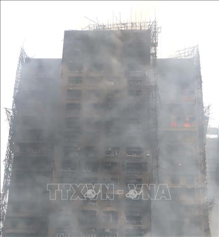 Lửa vẫn cháy âm ỉ trong một số căn hộ ở tầng cao. Ảnh: Xuân Vịnh - PV TTXVN tại Hong Kong (Trung Quốc) 