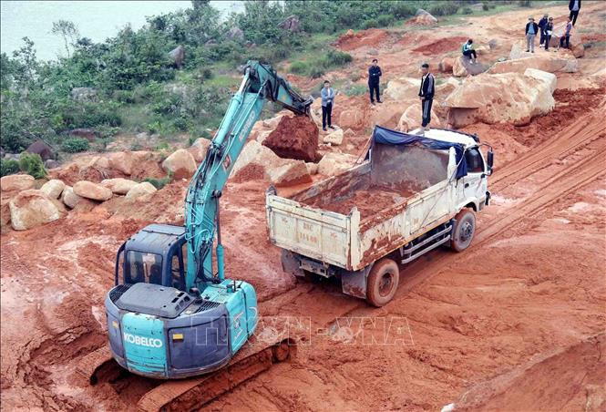 Lực lượng chức năng huy động phương tiện san hốt đất đá trên tuyến đường ven biển ĐT.547 thuộc địa phận xã Kỳ Xuân, tỉnh Hà Tĩnh. Ảnh: Công Tường-TTXVN