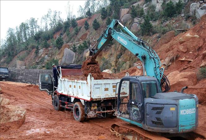 Lực lượng chức năng huy động phương tiện san hốt đất đá trên tuyến đường ven biển ĐT.547 thuộc địa phận xã Kỳ Xuân, tỉnh Hà Tĩnh. Ảnh: Công Tường-TTXVN