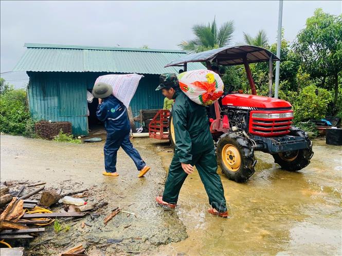 Lực lượng tại chỗ hỗ trợ di dời, vận chuyển phân bón, nông sản cho người dân để tránh lũ ở Lâm Đồng. Ảnh: TTXVN phát