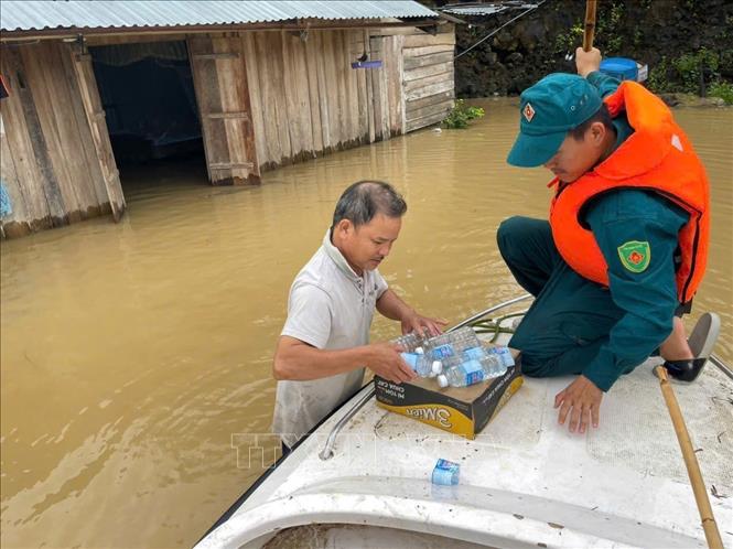 Hỗ trợ nước sạch, thực phẩm cho người dân trong khi chờ nước lũ rút. Ảnh: TTXVN phát