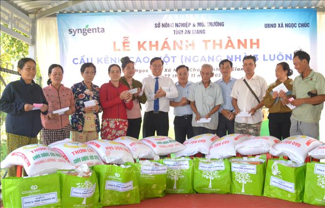 Lãnh đạo Công ty Syngenta Việt Nam trao quà cho hộ nghèo, cận nghèo, hộ Khmer nhân dịp lễ bàn giao cầu. Ảnh: Văn Sĩ - TTXVN
